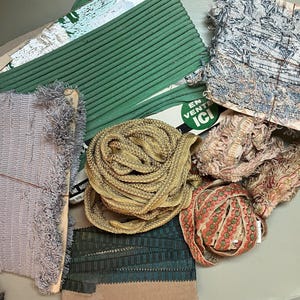 Puede incluir: Una colección de varios adornos y cintas decorativas en tonos verdes, dorados, rosas y azules. El surtido incluye cintas con cordones, flecos y estampadas, algunas aún en sus carretes de cartón originales.