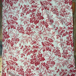 Può includere: Un pezzo di tessuto rettangolare bianco con un motivo ripetuto di fiori rosso scuro e steli di bambù. Il design copre l'intera superficie del tessuto, mostrando dettagliate illustrazioni botaniche di fiori e foglie.