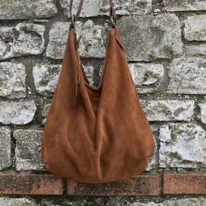 Hobo-Tasche aus tabakfarbenem Wildleder mit Reißverschluss.