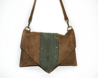 May include: A brown suede crossbody bag with a green suede flap and decorative metal accents.