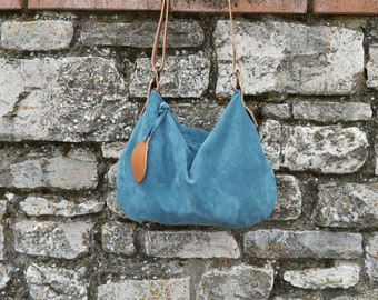 Sac bandoulière en daim bleu poudré et bandoulière beige avec zip.