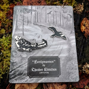 May include: A pin set featuring a stylized illustration of a reclining figure and a flying bird, set against a grayscale forest scene. The set includes a rectangular plaque with the text "Fattigmannen" by Theodor Kittelsen (1857-1914).