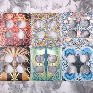 May include: Six different decorative outlet covers with various floral and geometric patterns. The covers are all square and have three holes for outlets.
