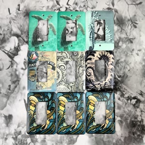 May include: Set of ten light switch covers with various designs. The designs include seahorses, jellyfish, sea turtles, and nautical maps. The switch covers are white with a glossy finish.