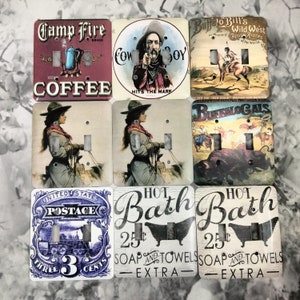 May include: Set of ten vintage-style light switch covers featuring various designs, including a cowboy, a buffalo, a camp fire, a hot bath, and a postage stamp. The switch covers are made of metal and have a distressed look.