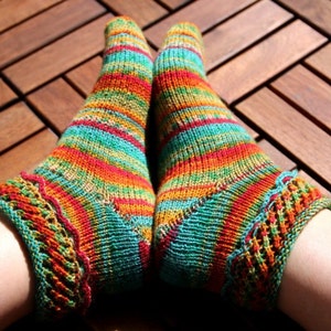 Peut inclure: Une paire de chaussettes rayées colorées avec une bordure en dentelle. Les chaussettes sont en tissu tricoté doux et présentent une variété de couleurs, notamment le rouge, l'orange, le jaune, le vert et le bleu.