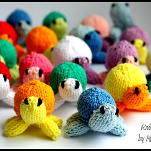Peut inclure: Une collection de jouets en forme de tortues en tricot de différentes couleurs. Les tortues sont faites dans une variété de couleurs, y compris le rouge, l'orange, le jaune, le vert, le bleu et le violet. Les tortues mesurent environ 7,5 cm de haut et ont un design mignon et fantaisiste.