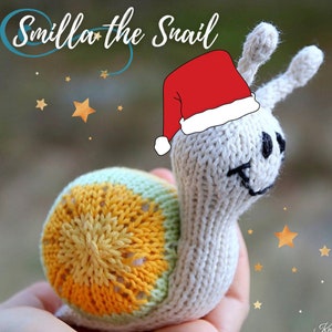 May include: A knitted snail wearing a red Santa hat with white trim. The snail's shell is yellow, green, and white. The snail is holding a star in its hand.
