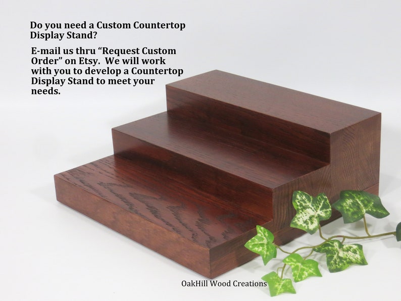 May include: Three-tiered wooden display stand made of dark red stained wood. The stand is made of solid wood and has a natural wood grain. The stand is perfect for displaying small items, such as jewelry, candles, or figurines.  Do you need a Custom Countertop Display Stand? E-mail us thru "Request Custom Order" on Etsy. We will work with you to develop a Countertop Display Stand to meet your needs. OakHill Wood Creations