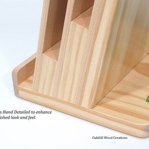 May include: A wooden stand with three slots for holding items. The stand is made of light wood with a natural finish. The stand is hand-detailed to enhance the finished look and feel. OakHill Wood Creations is printed on the base of the stand.