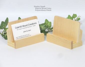 May include: Two natural wood business card holders with a polyurethane finish. The holder on the left has a business card that reads "OakHill Wood Creations, We Create Tomorrows Heirlooms - Today! John & Joan, www.OakHillWoodCreations.com, E-Mail: Sales@oakhillwoodcreations.com"