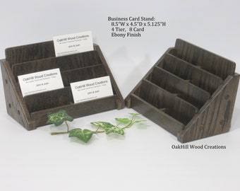 May include: Two wooden business card holders with an ebony finish. Each holder has four tiers and can hold eight cards. The holders are 8.5 inches wide, 4.5 inches deep, and 5.125 inches high. The text "OakHill Wood Creations" is printed on the front of each holder.