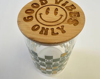 Frasco de vidrio con la frase "Solo buenas vibras" y tapa de madera grabada con láser