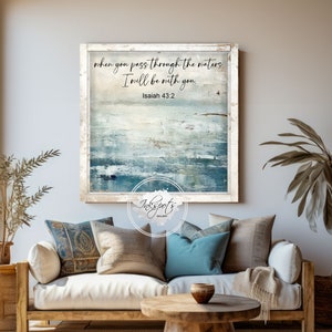 May include: A framed canvas print with a blue and white abstract design. The text "when you pass through the waters, I will be with you. Isaiah 43:2" is printed on the canvas.