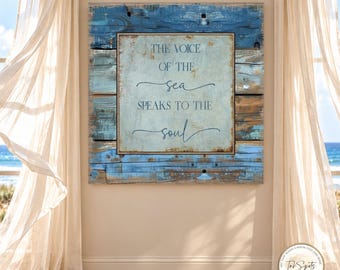 May include: A square wall art piece featuring a central light blue panel with the text THE VOICE OF THE sea SPEAKS TO THE soul in dark blue font, framed by a border of weathered, horizontal blue and brown wooden planks.