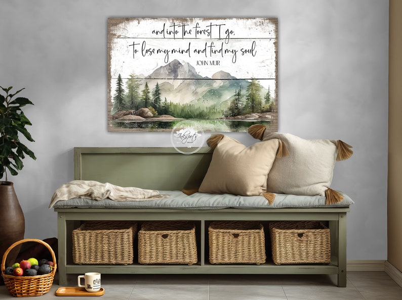 May include: A wood sign with a watercolor painting of a forest scene with mountains, trees, and a lake. The sign has the text "and into the forest I go. To lose my mind and find my soul JOHN MUIR" on it.