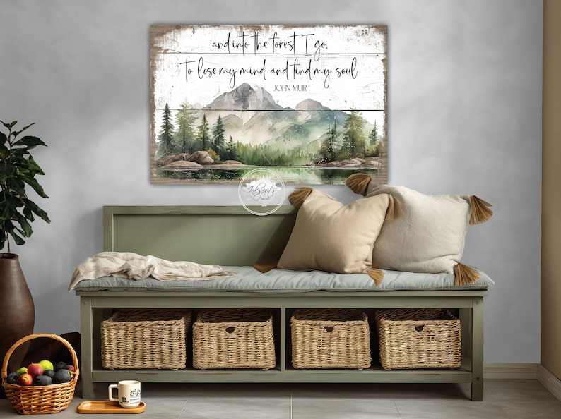 May include: A wood sign with a watercolor painting of a forest scene with mountains, trees, and a lake. The sign has the text "and into the forest I go. To lose my mind and find my soul. JOHN MUIR"