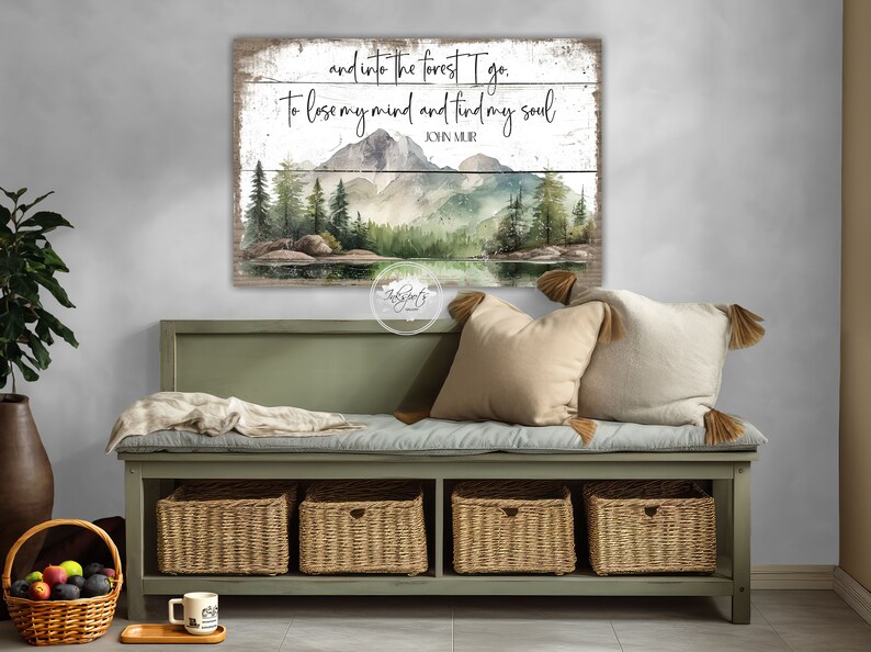 May include: A wood sign with a watercolor painting of a forest scene with mountains, trees, and a lake. The sign has the text "and into the forest I go. To lose my mind and find my soul" and "JOHN MUIR".