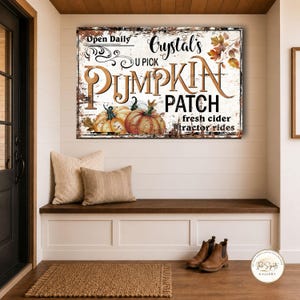 May include: A rectangular wall sign with a distressed white background featuring the text Crystal's U Pick PUMPKIN PATCH, Open Daily, fresh cider, and tractor rides. The design includes illustrations of orange pumpkins and autumn leaves.