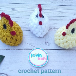 May include: Three crocheted chicks in yellow, white, and cream colors with red combs and black eyes. The chicks are sitting on a white wooden surface. A white circle with the text "lovin knit" is in the center of the image. The text "crochet pattern" is below the circle.