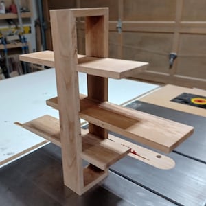 Op de afbeelding: Een houten plankeneenheid met drie planken. De planken zijn gemaakt van onbehandeld hout en zijn in een verspringend patroon gerangschikt.