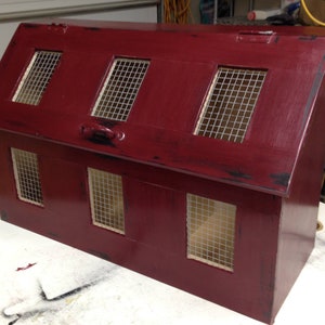 May include: A red wooden barn with a gabled roof and five windows with wire mesh screens. The barn is painted a deep red with black accents and has a distressed finish.