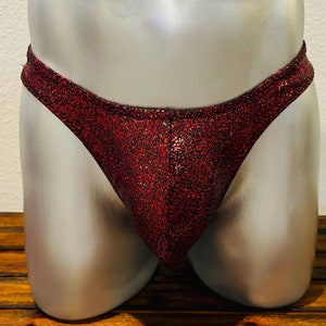 May include: Red glitter swimsuit bottom with a low rise and a thong back.