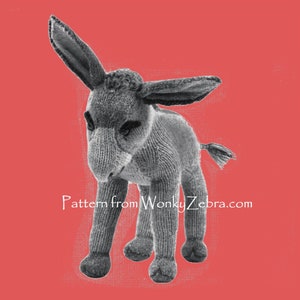 Pode incluir: Um brinquedo de burro de malha cinzento com uma cauda longa e orelhas grandes. O brinquedo está em pé sobre um fundo vermelho. Padrão de WonkyZebra.com