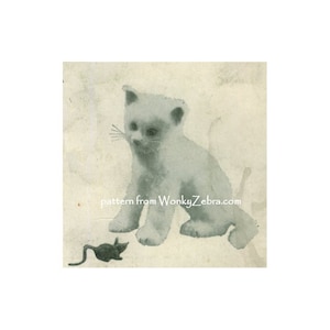 May include: A white kitten with blue eyes sits on a beige background, looking to the left. A small gray mouse toy is on the floor in front of the kitten. The text "pattern from WonkyZebra.com" is at the bottom of the image.