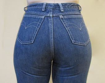 Puede incluir: Un par de pantalones vaqueros azules de mezclilla con costuras blancas. Los pantalones tienen cintura alta y pierna recta.