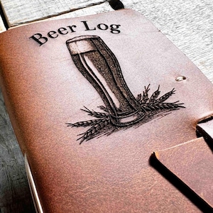 May include: A brown leather journal with the words "Beer Log" embossed on the front cover. A glass of beer with wheat stalks is also embossed on the cover.