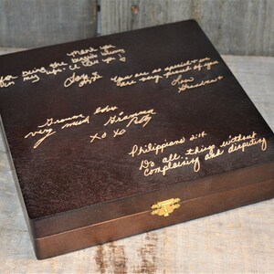 May include: A dark brown wooden box with a gold latch. The top of the box is engraved with handwritten messages, including "Thank you for being the best mommy", "Grandma love very much", "Philippians 2:14 Do all things without complaining and disputing", and other messages.