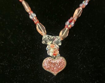 Pink heart necklace with vintage light pink and clear crystal beads. Heart is also vintage, bright pink, Barbie-themed.