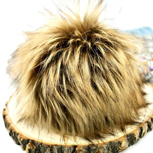 May include: A fluffy brown and black faux fur pom pom, ideal for adding a touch of warmth and texture to hats, scarves, or other accessories.
