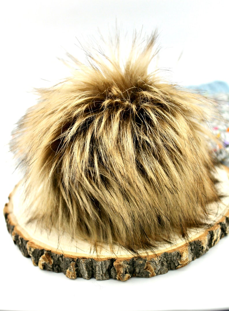 May include: A fluffy brown and black faux fur pom pom, ideal for adding a touch of warmth and texture to hats, scarves, or other accessories.