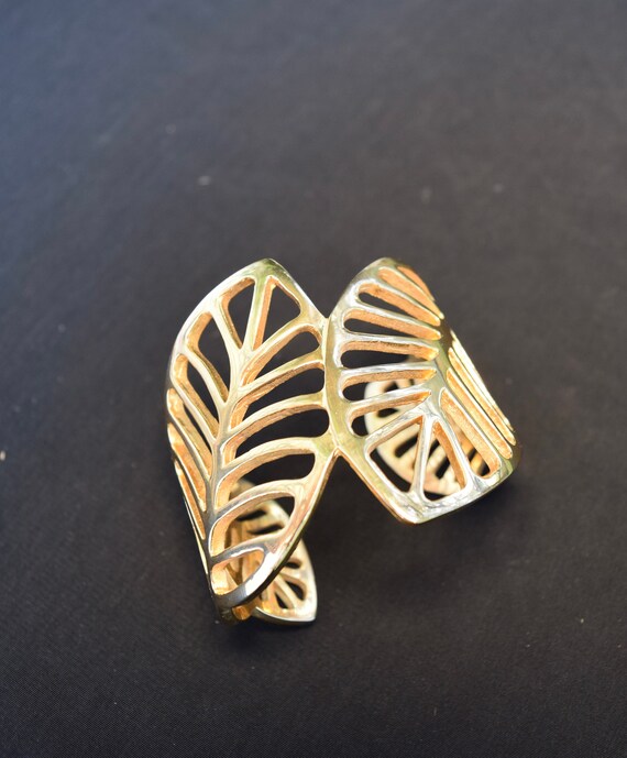 Open work gold tone bracelet in leaf motif. Gold l