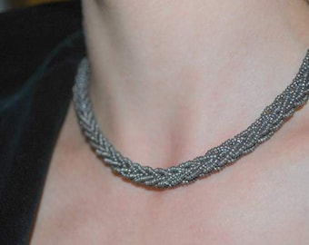 Grått glaspärlehalsband i vackert flätat mönster. Halsband med pärlor från 1940-talet.