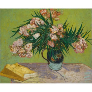 May include: A still life painting by Vincent van Gogh featuring a bouquet of pink oleander flowers in a blue and green ceramic vase. The flowers are arranged in a vase on a table with a yellow book.