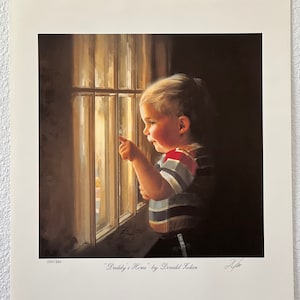 May include: A framed print titled "Daddy's Home" by Donald Zolan. The artwork depicts a young child with blond hair, wearing a striped shirt, looking out a window and pointing. The print has a warm, inviting color palette.