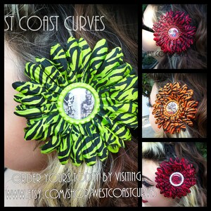 May include: A collection of fabric flower hair accessories. One flower is lime green with black zebra stripes, featuring a central image. Other flowers are red, orange, and red with black stripes. The text "WEST COAST CURVES" and "ORDER YOURS TODAY BY VISITING..." are visible.