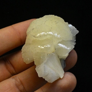 以下が含まれることがあります： 層状で縞模様のテクスチャを持つ、半透明の白と黄色のカルサイト結晶のクラスターです。