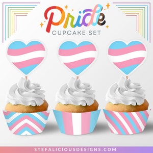 Op de afbeelding: Een set cupcake-verpakkingen en -toppers met de kleuren van de transgender pride-vlag. De verpakkingen zijn in roze en blauwe strepen en chevron-patronen. De toppers zijn hartvormig met de kleuren van de transgender pride-vlag.