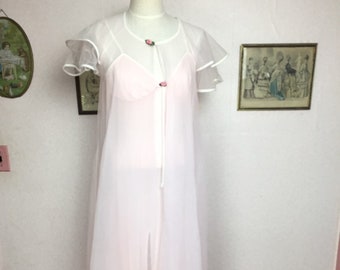 May include: A sheer pink and white robe with a ruffled collar and sleeves. The robe has a tie closure at the front and features two small pink flower buttons.