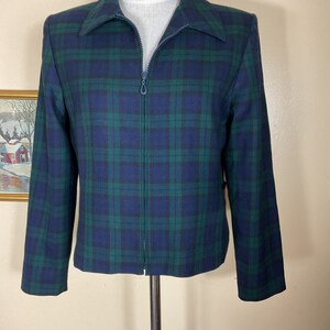 May include: A blue and green plaid jacket with a zipper closure. The jacket has a collared neckline and long sleeves.