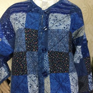 May include: A blue patchwork jacket with a button-up front and a variety of patterns, including floral, geometric, and animal print.