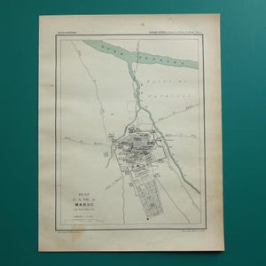 May include: An antique paper map titled Plan de la Ville de MAROC (MERRAKECH) from the Atlas Universel. The map features black ink lines on a cream background, depicting city streets, a river labelled Oued Tensift, and surrounding terrain.