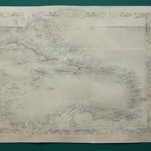 Op de afbeelding: Een antieke zwart-wit papieren kaart van de West-Indische Eilanden met gedetailleerde kustlijnen, topografische markeringen en nautische labels. De kaart is ingesloten in een sierlijke decoratieve rand en bevat de tekst West India Islands.