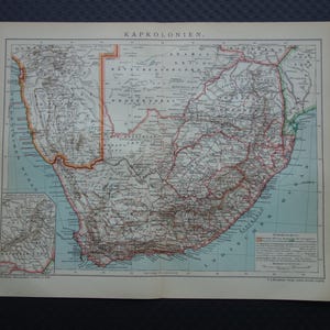 Puede incluir: Mapa antiguo de las Colonias del Cabo, con información geográfica detallada. El mapa está impreso en papel envejecido, con el texto "KAPKOLONIEN" en la parte superior. Incluye varios nombres de lugares y fronteras, con un pequeño mapa en la esquina inferior izquierda.