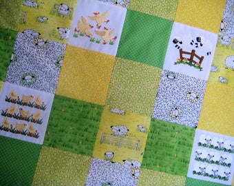 Puede incluir: Una colcha de retazos con un esquema de color amarillo, verde y blanco. La colcha presenta un patrón repetitivo de pollitos y ovejas.