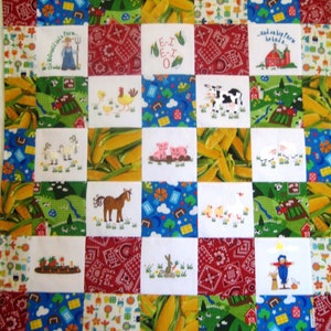 May include: A colorful patchwork quilt with a farm theme. The quilt is made up of squares with different images, including a farm, animals, and corn. The quilt is white with red, blue, green, and yellow accents. The text "E-I E-I O" is embroidered on one of the squares.